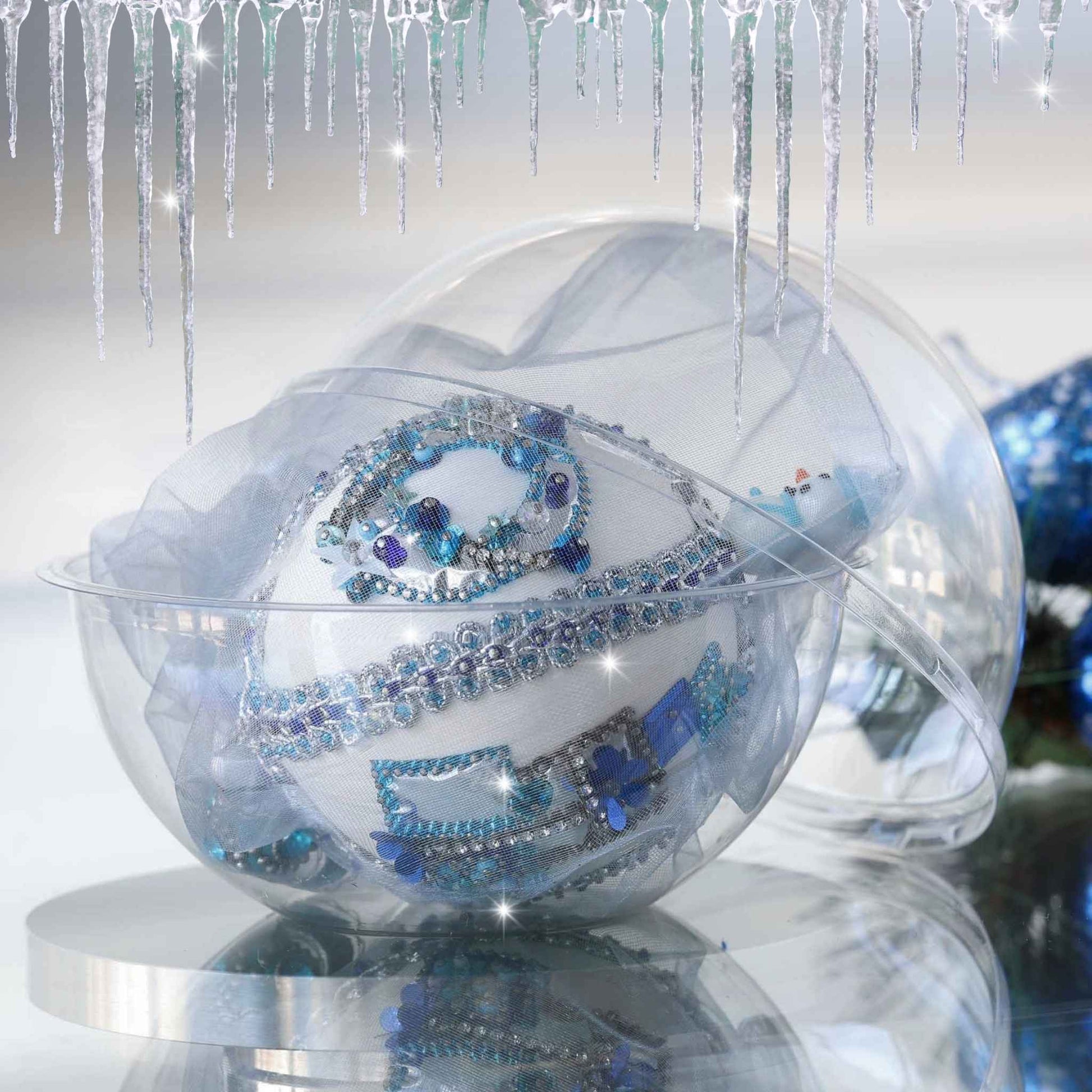 Handmade completed Christmas push pin satin ornament with silver sequins inside a round clear storage container, with a blue shiny decorations on a light background by Whim5seasons.