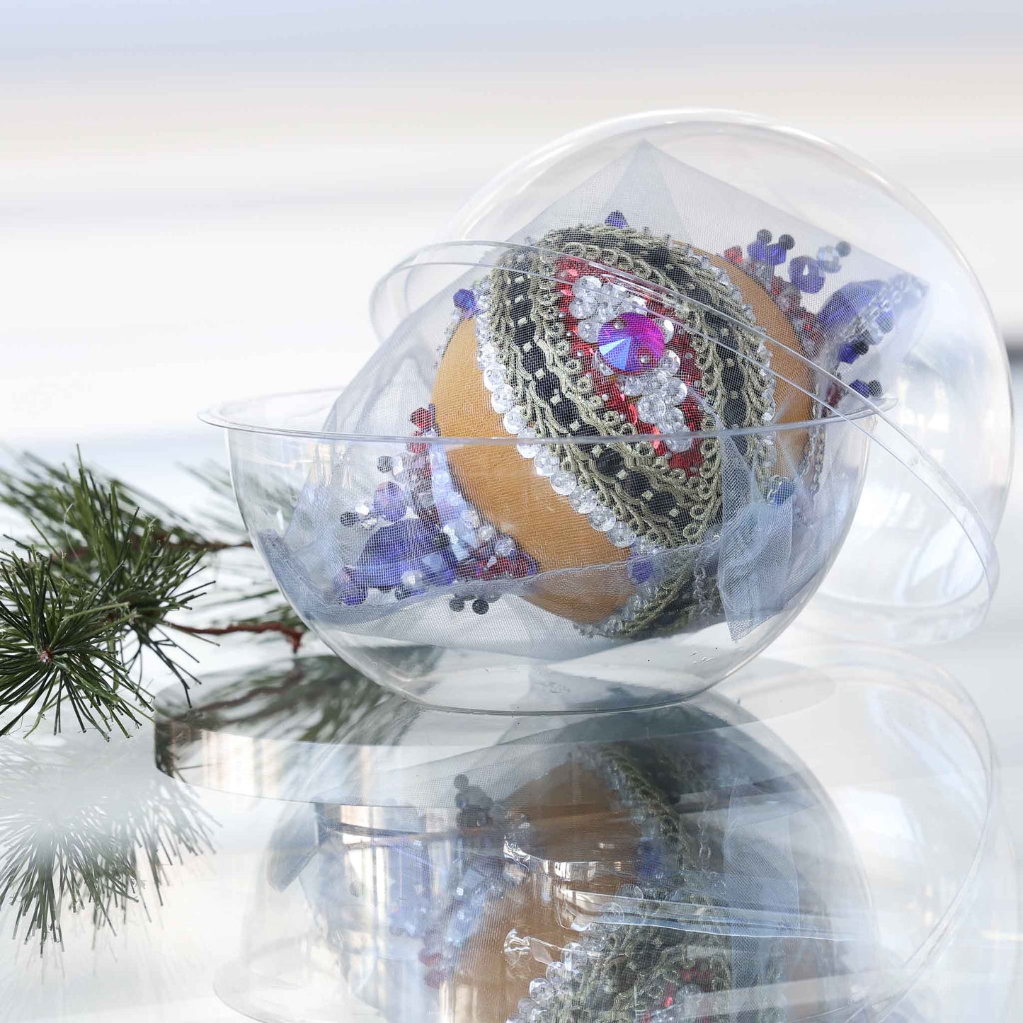 Handmade satin push pin ornament in a clear storage container, richly embellished with red round rhinestones, gold trim, rows of silver sequins, and large blue beads by Whim5seasons.