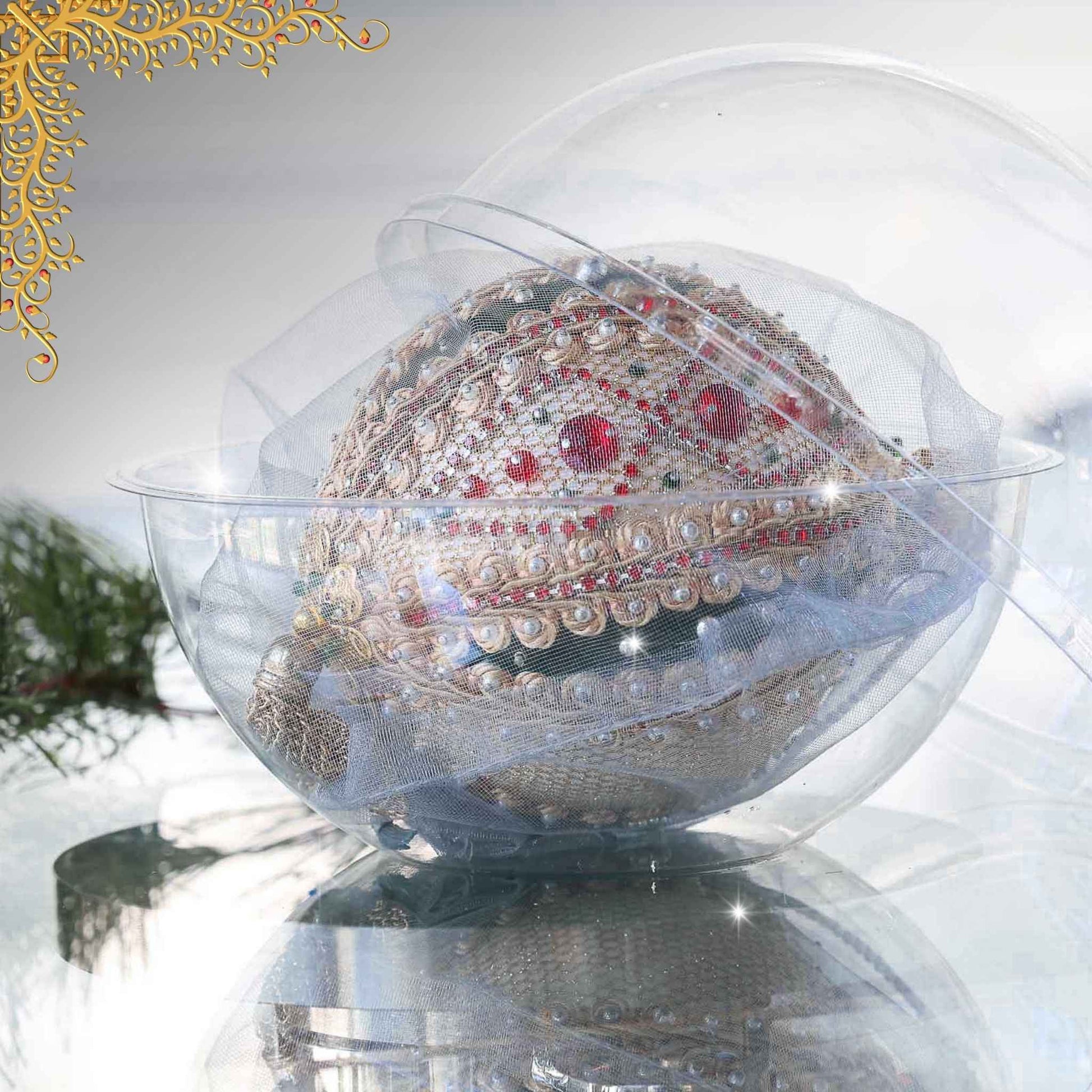 Handmade Christmas beaded ornament with intricate design on a reflective surface in a clear storage box with an evergreen branch in the background by Whim5seasons.