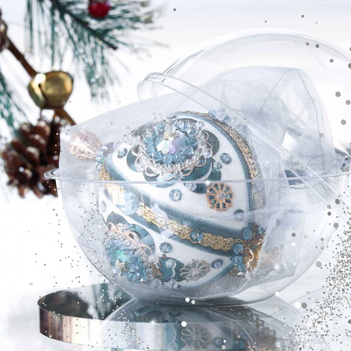 Handmade retro Christmas beaded ornament with intricate design on a reflective surface in a clear storage box with an evergreen branch in the background by Whim5seasons.