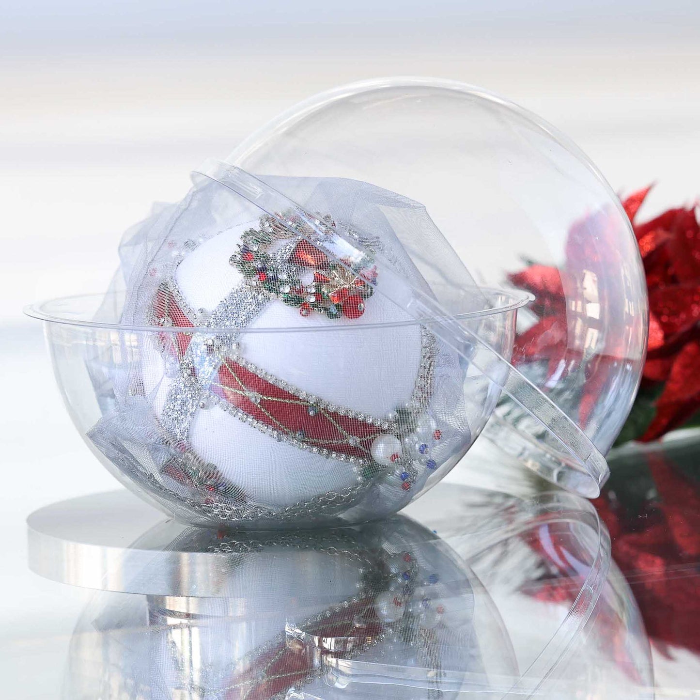 Handmade satin beaded white Christmas ornament embellished with beads and trims in front of gray background and holiday greenery in a clear plastic container  by Whim5seasons.