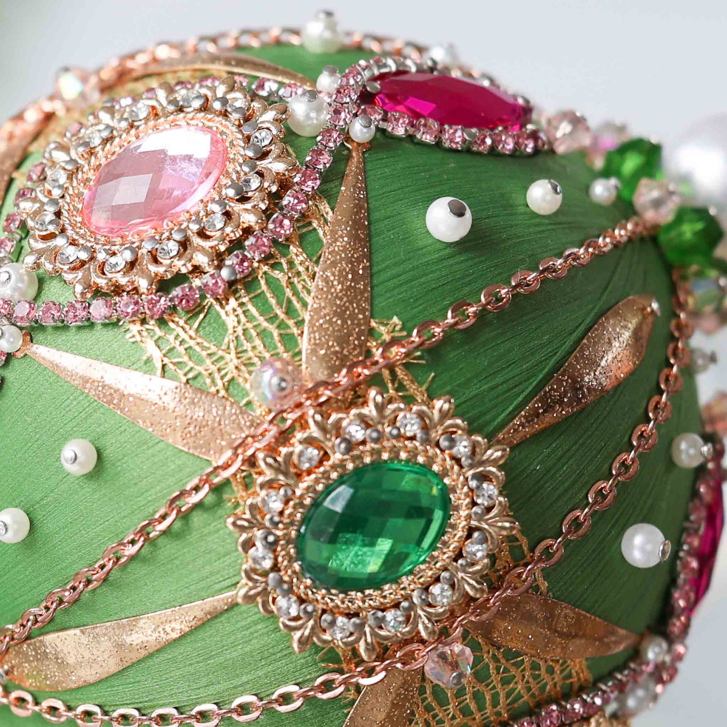 Close-up detail of a handmade beaded Christmas ornament with pink and green beades secured in place with dressmaker pins by Whim5seasons. (Olive)