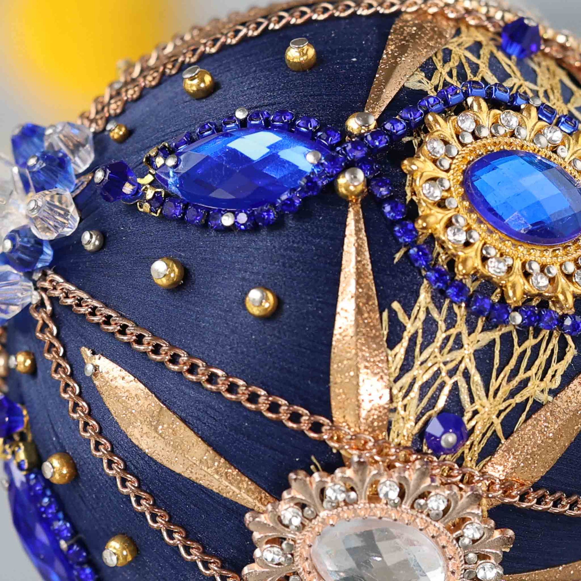 Close-up detail of a handmade satin push pin Christmas ornament with large blue rhinestones and gold chains secured in place with dressmaker pins by Whim5seasons. (Navy)