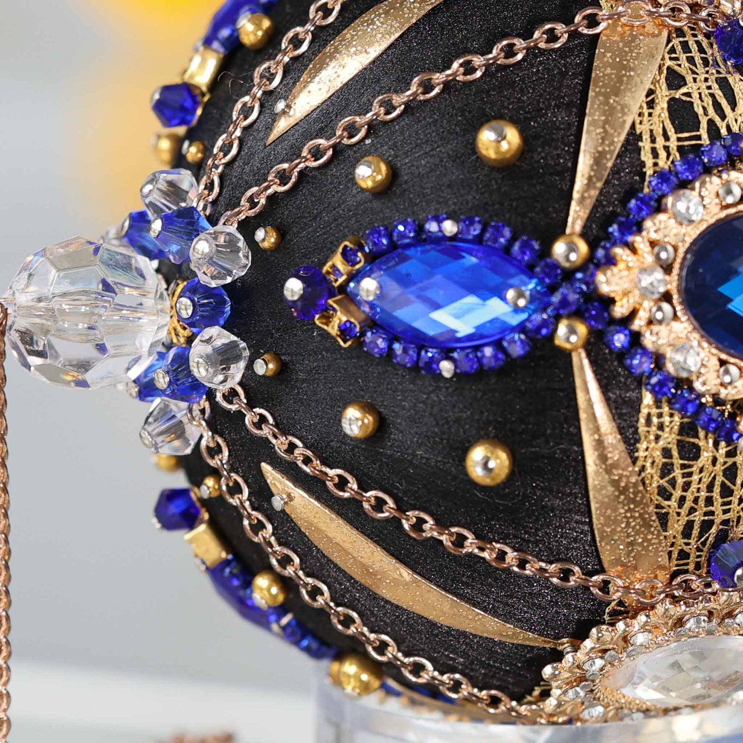 Close-up detail of a black handcrafted satin Christmas ornament with blue and clear beads pinned to the satin foam core with dressmaker pins by Whim5seasons. (Black)