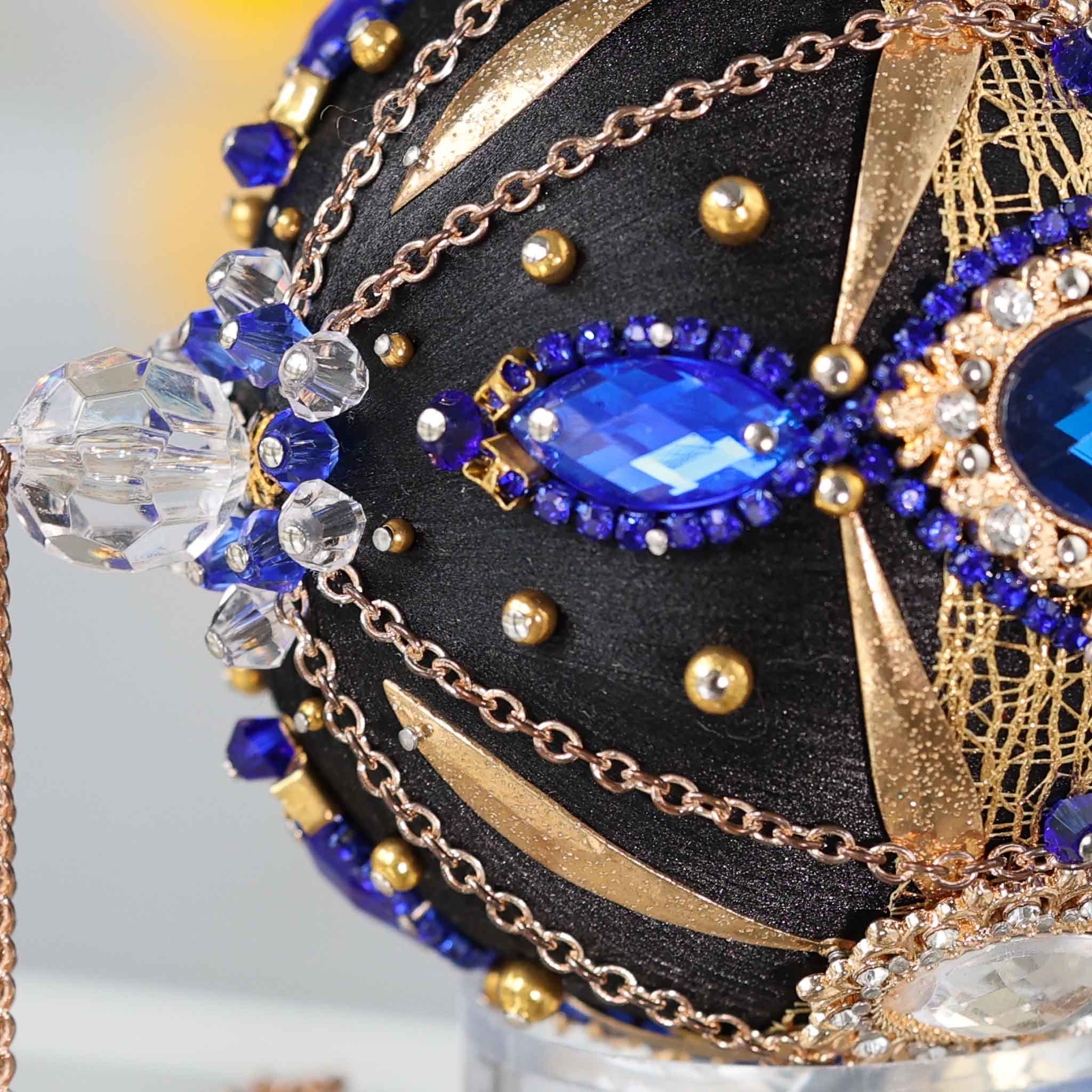 Close-up detail of a black handcrafted satin Christmas ornament with blue and clear beads pinned to the satin foam core with dressmaker pins by Whim5seasons. (Black)