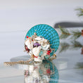 Load image into Gallery viewer, Close-up of a decorative teal push pin satin ball wrapped in mesh showing small beads, and real shells pinned with dressmaker pins by Whim5seasons.
