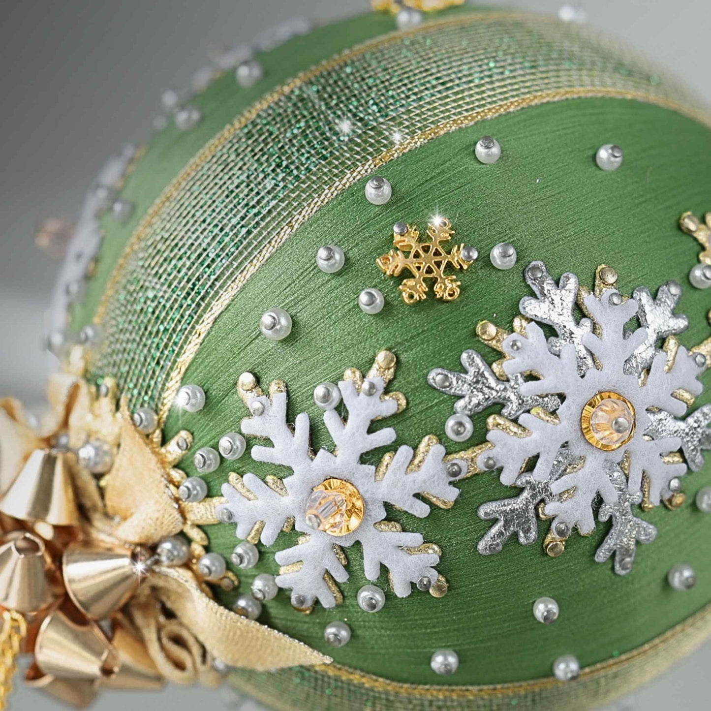 Close-up detail of a black handcrafted satin Christmas ornament with white and gold trims and clear beads pinned to the satin foam core with dressmaker pins by Whim5seasons.