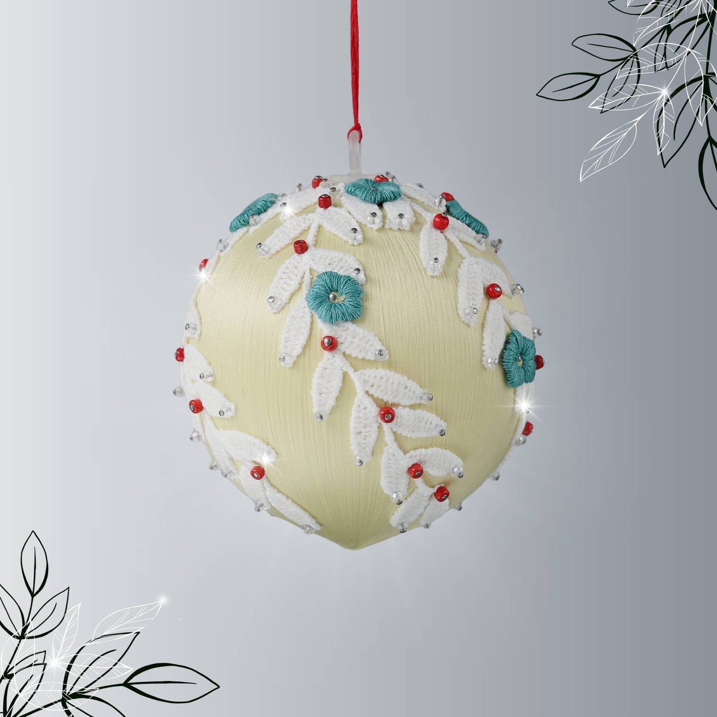 Handmade push pin beaded Christmas Ornament Ball embellished with embroidered flowers, white lace trim, and small clear beads hanging from a green evergreen branch by Whim5seasons.