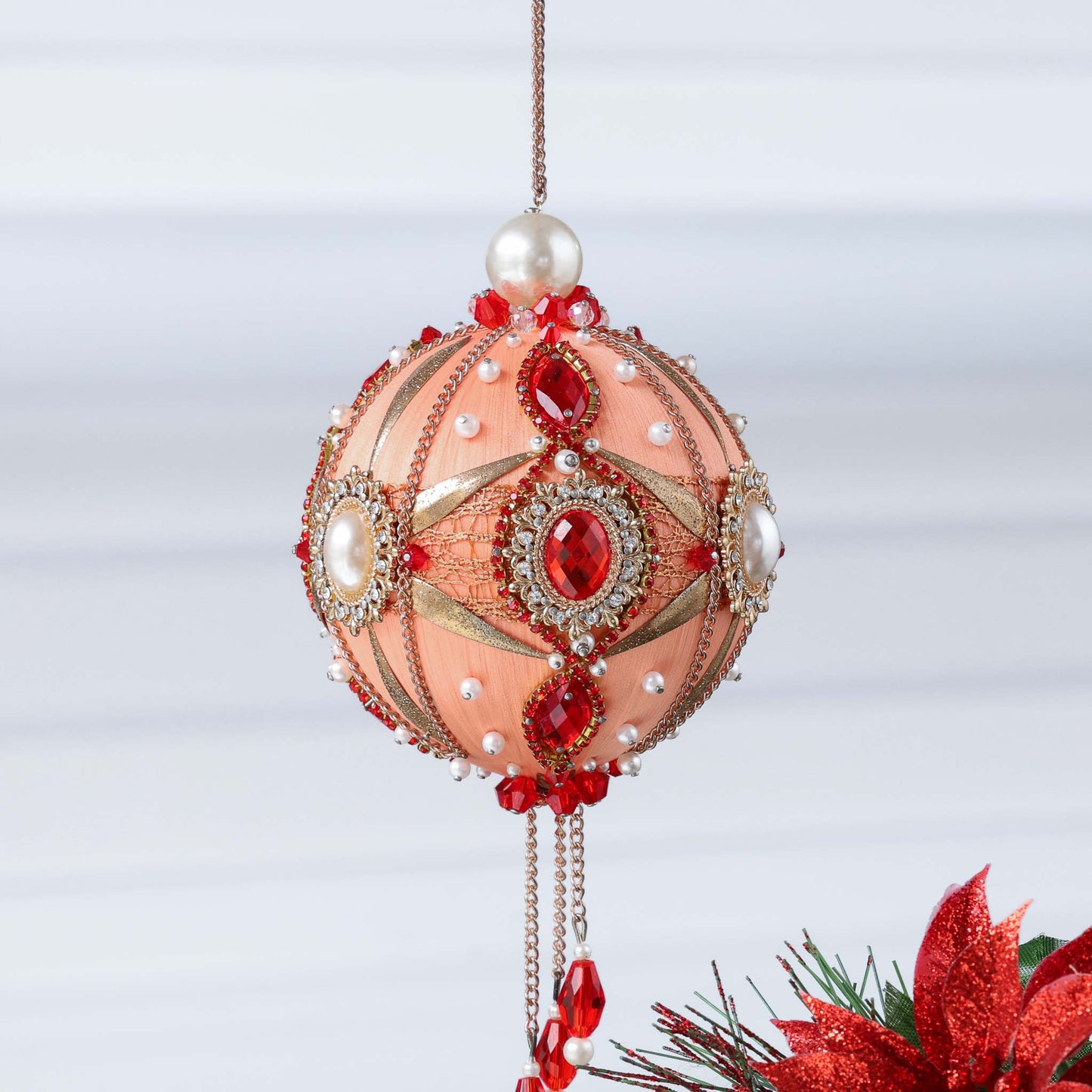 Handmade ornament in a light coral color featuring stunning alloy and crystal framed pearl cameos, rhinestone chain, rose gold chain, hanging on a light gray background by Whim5seasons. (Coral)