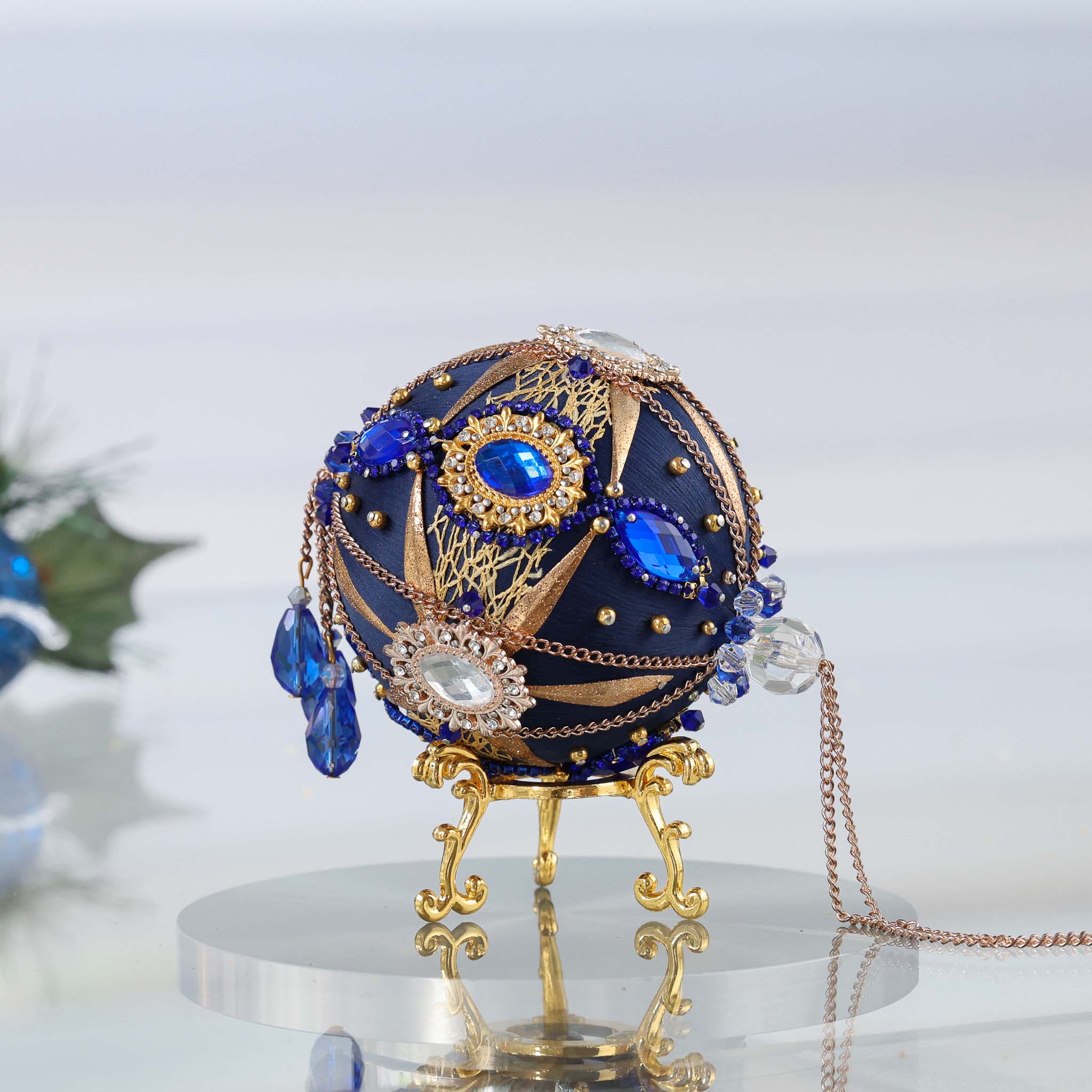 A side of a satin handcrafted dark blue  push pin Christmas ornament with gold beads and cameos applied to the satin foam core with dressmaker pins by Whim5seasons. (Navy)