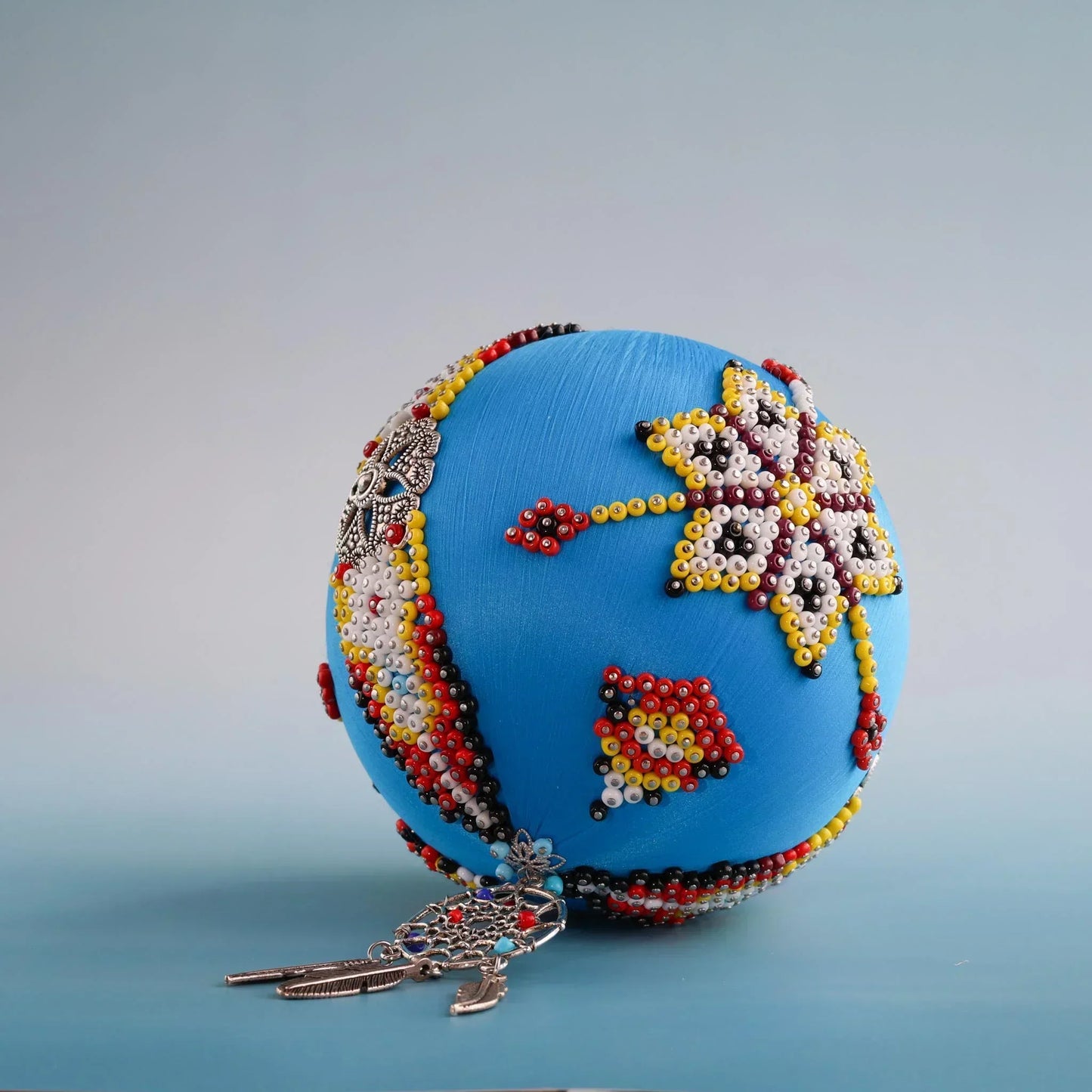 Handmade push pin Christmas satin ornament inspired by indigenous beadwork and patterns on a gray background by Whim5seasons.