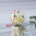 Load image into Gallery viewer, Handmade push pin beaded Christmas Ornament Ball embellished with teal fabric flowers, white lace trim, and small clear beads on a reflective surface with holiday greenery. (Khaki)
