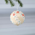 Load image into Gallery viewer, Finished Mid-Century Style Frosted Laurel Satin Ornament in a light tan color with orange embroidered flowers pinned to a satin foam core on a reflective surface. (Papaya Whip)
