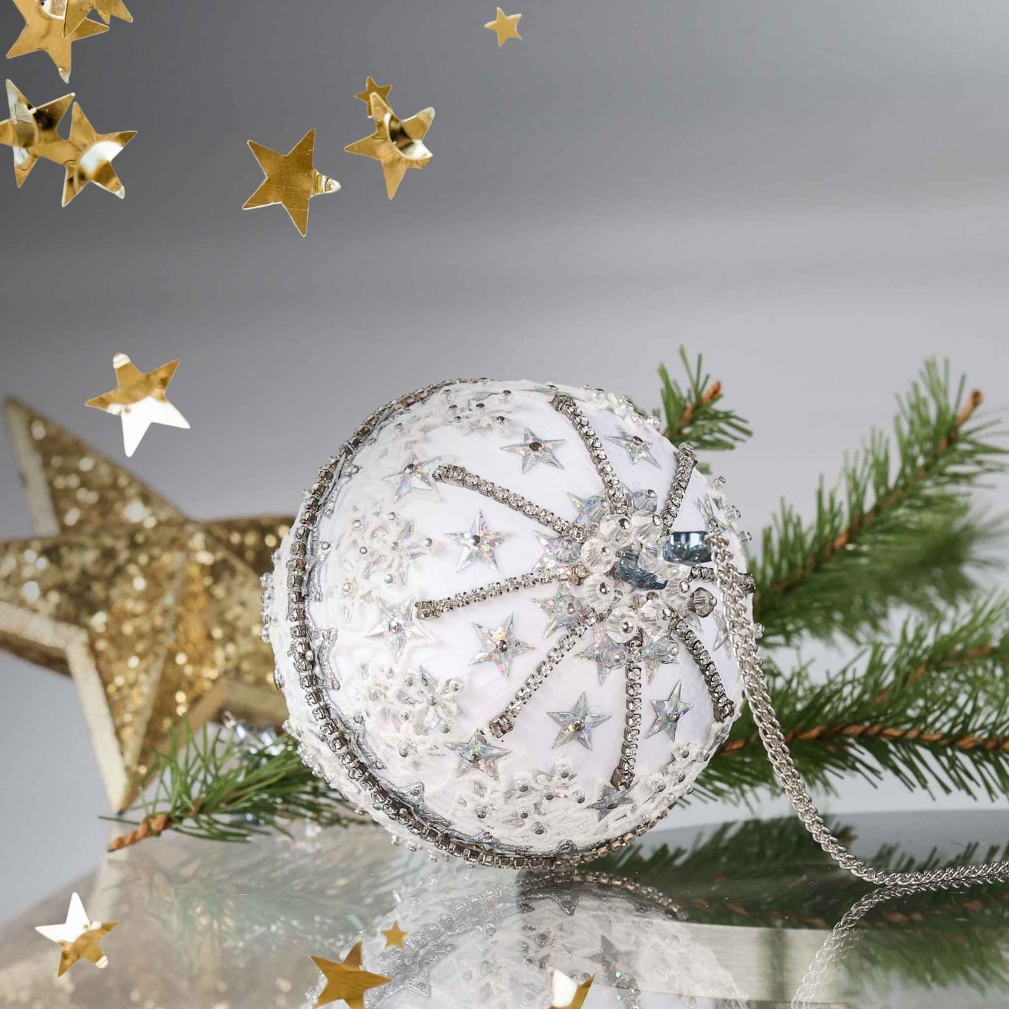 Completed Handmade Christmas Push  Pin Ornament with star design on a reflective surface with greenery and gold star in the background by Whim5seasons.