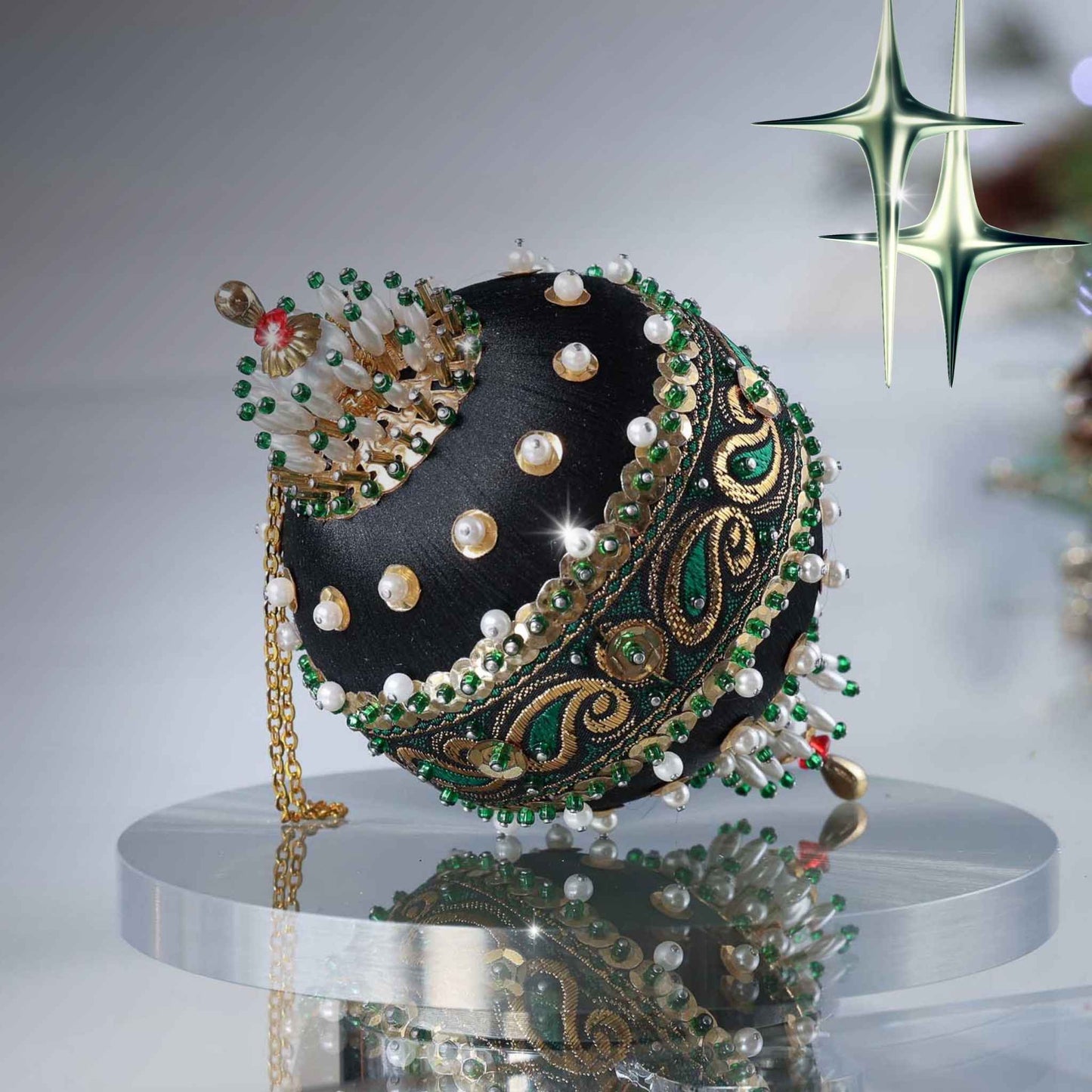 Handmade 1970 mid century black satin push pin ornament featuring pearls beads, black/gold/green trim, and gold sequins with a Christmas branch in the background by Whim5seasons.