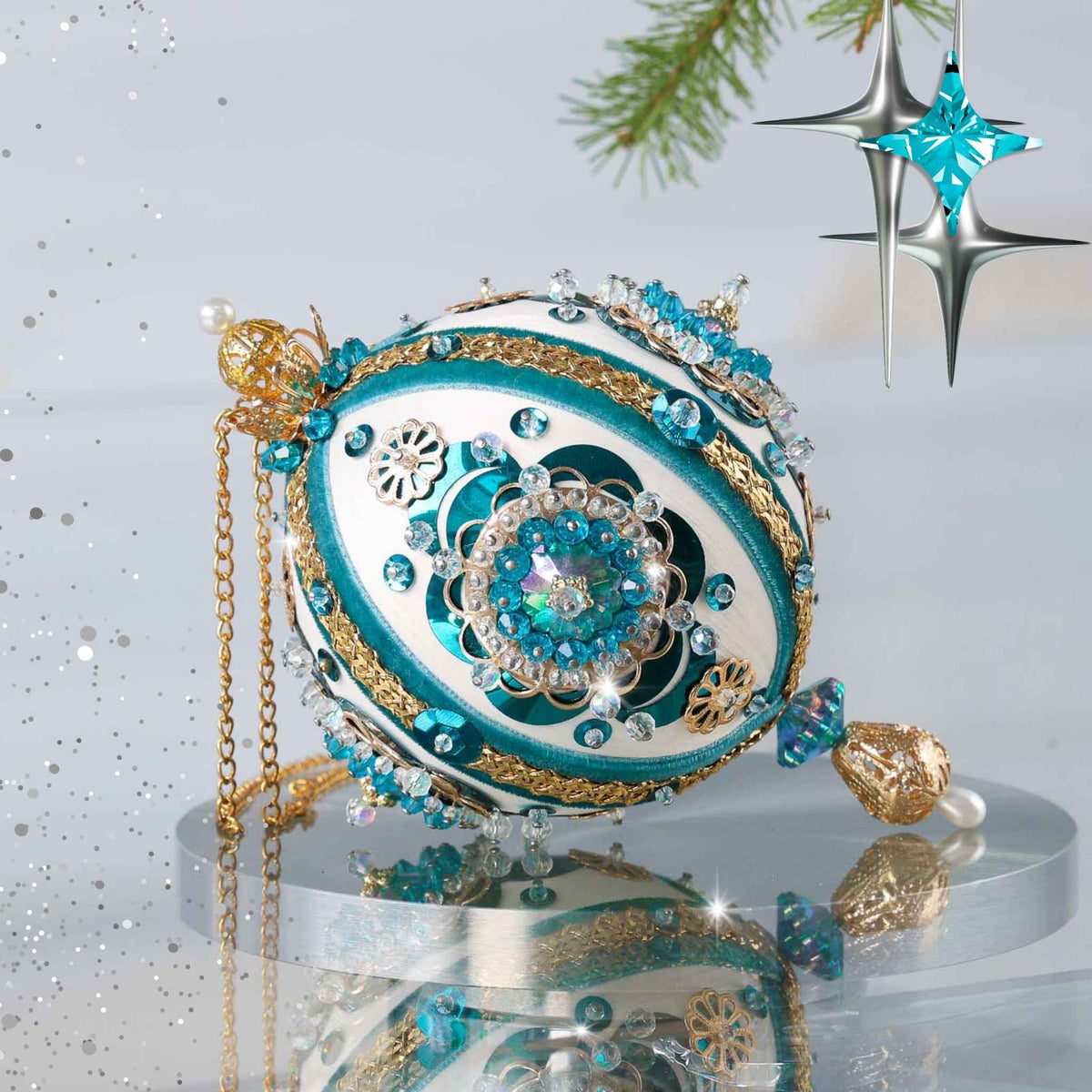 An ornate Christmas ornament shaped like an egg, decorated with turquoise blue, white, and gold patterns, crystals, and hanging gold chains, displayed on a reflective surface with festive star decorations in the background by Whim5seaons.