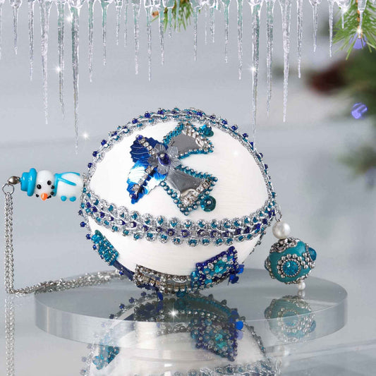 Handmade Christmas Satin Push Pin Ornament in white with blue sequined   bells and a large handcrafted bead on the bottom on a reflective surface by Whim5seasons.