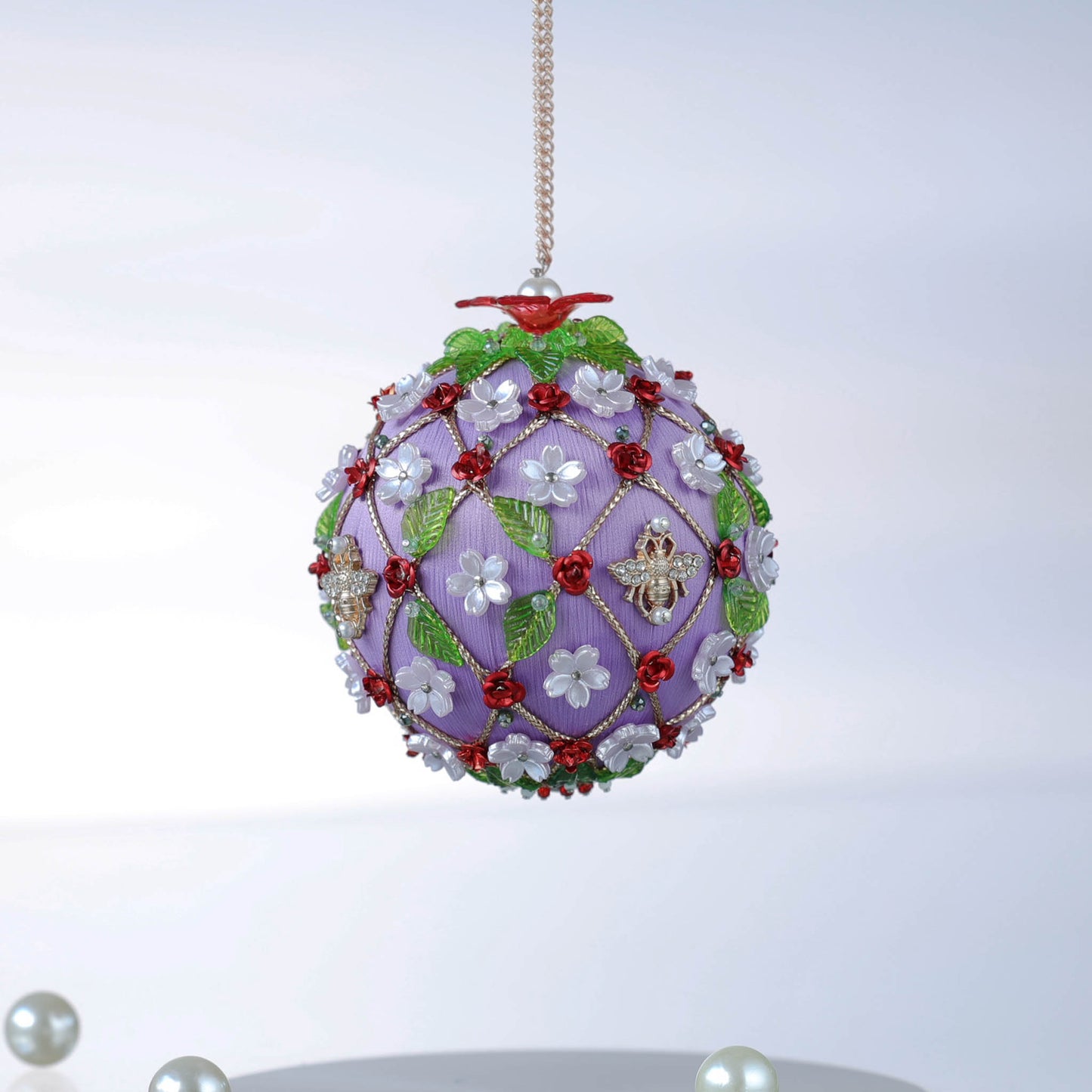 Handmade Christmas ornament with floral patterns and charms, hanging against a white background by Whim5seaons.