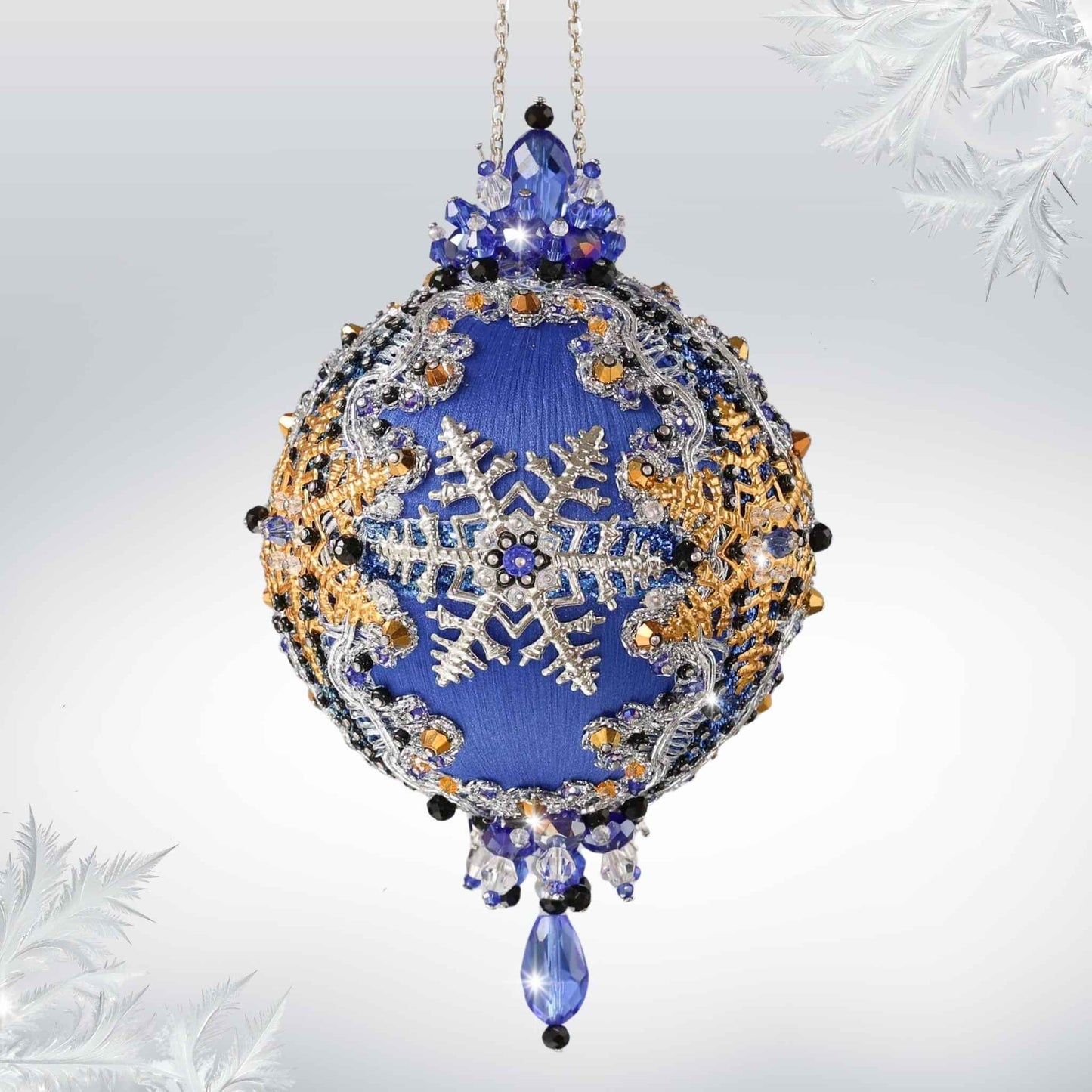 Handmade Christmas Satin Ornament with clear glass beads, silver snowflake, and a silver chain on a white background with a green holiday branch by Whim5seasons.