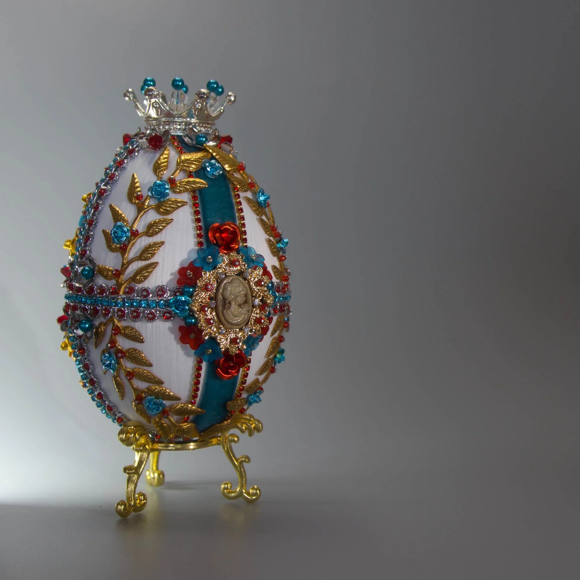 Decorative handmade satin Easter egg with intricate designs including gold laurel, royal cameo, silver trim, and sparkling beads to rival Faberge by Whim5seasons.