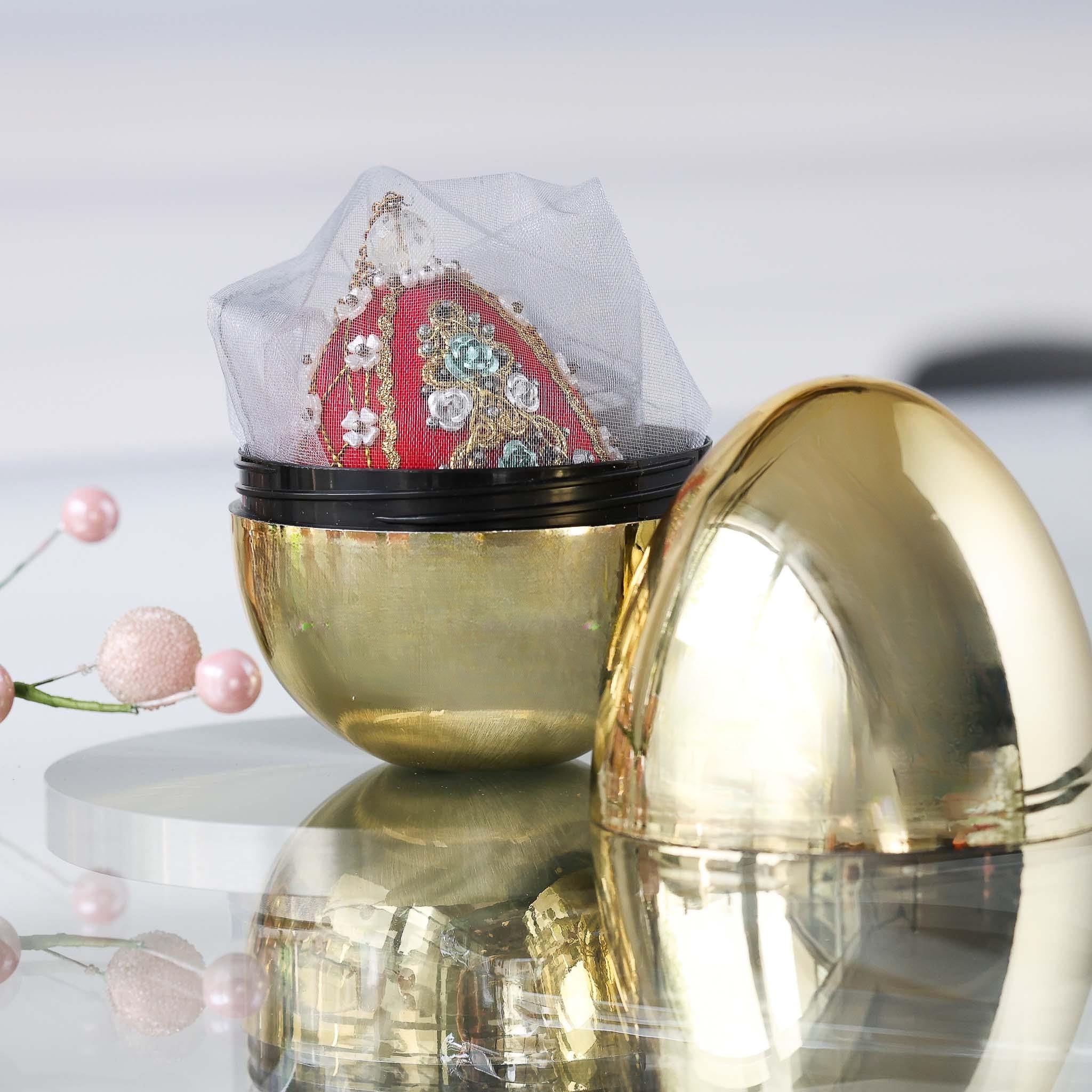 Decorative handmade easter push pin egg ornament in organza bag inside a gold storage container set against light gray background. (Dark Red)