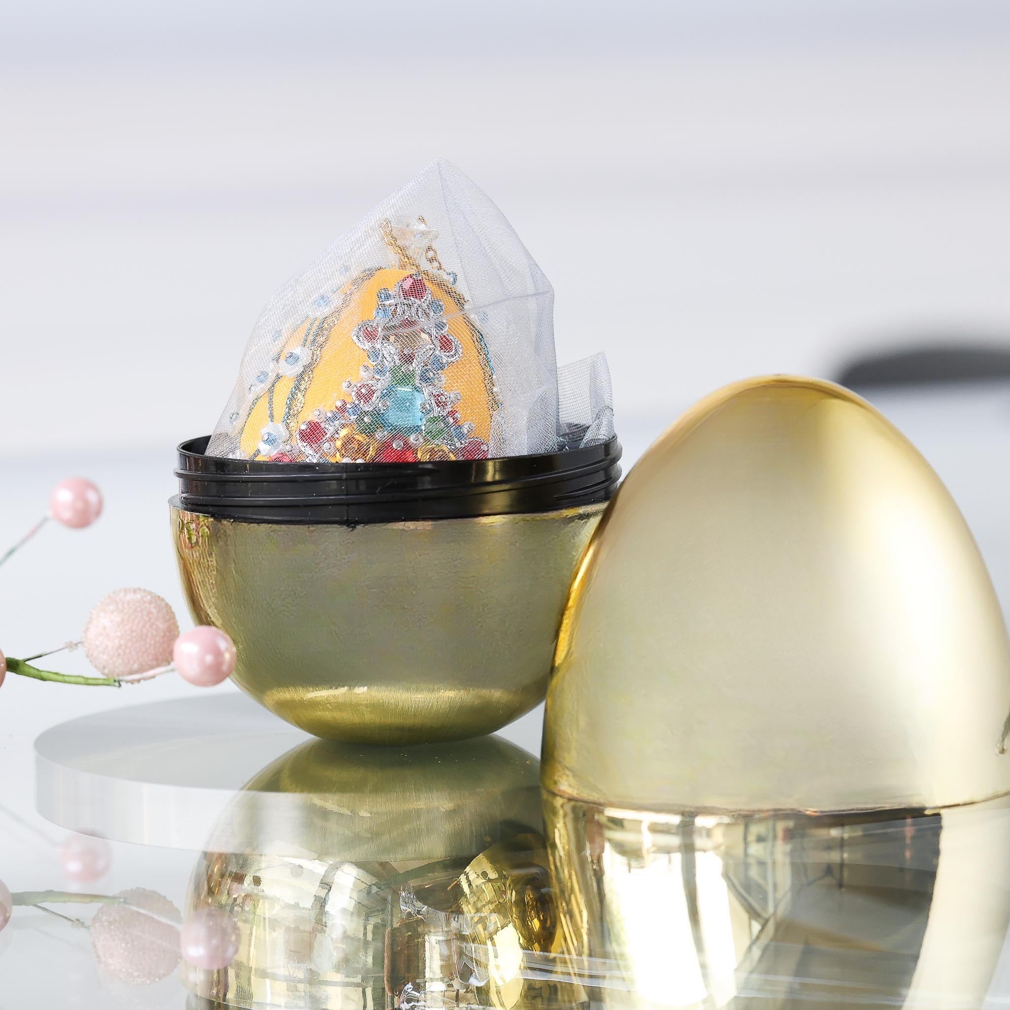 Festive handmade yellow easter push pin egg ornament in organza bag inside a gold storage container set against light gray background. (Dark Orange)