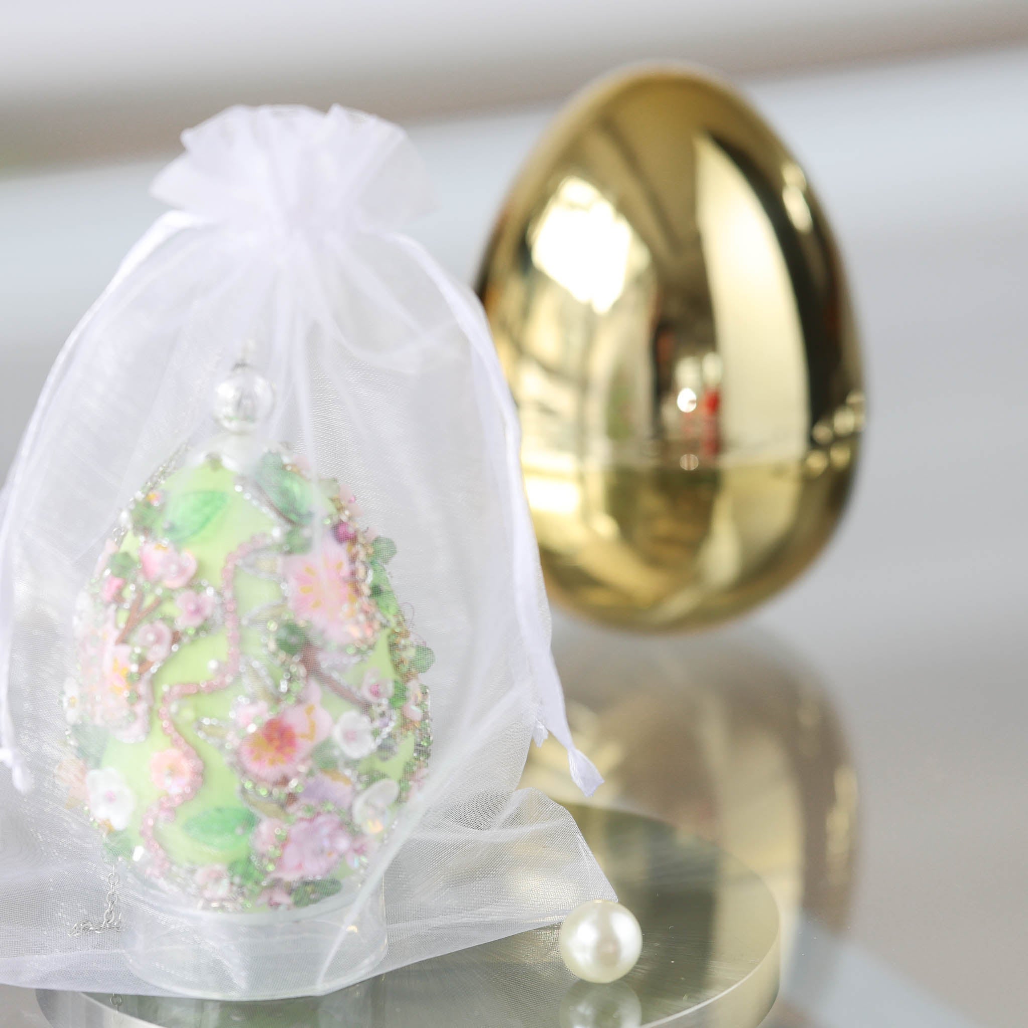 Handmade Easter Egg Push Pin Ornament in a see-through elegant organza bag with a large gold egg-shaped container in the background by Whim5seasons. (Dark Red)