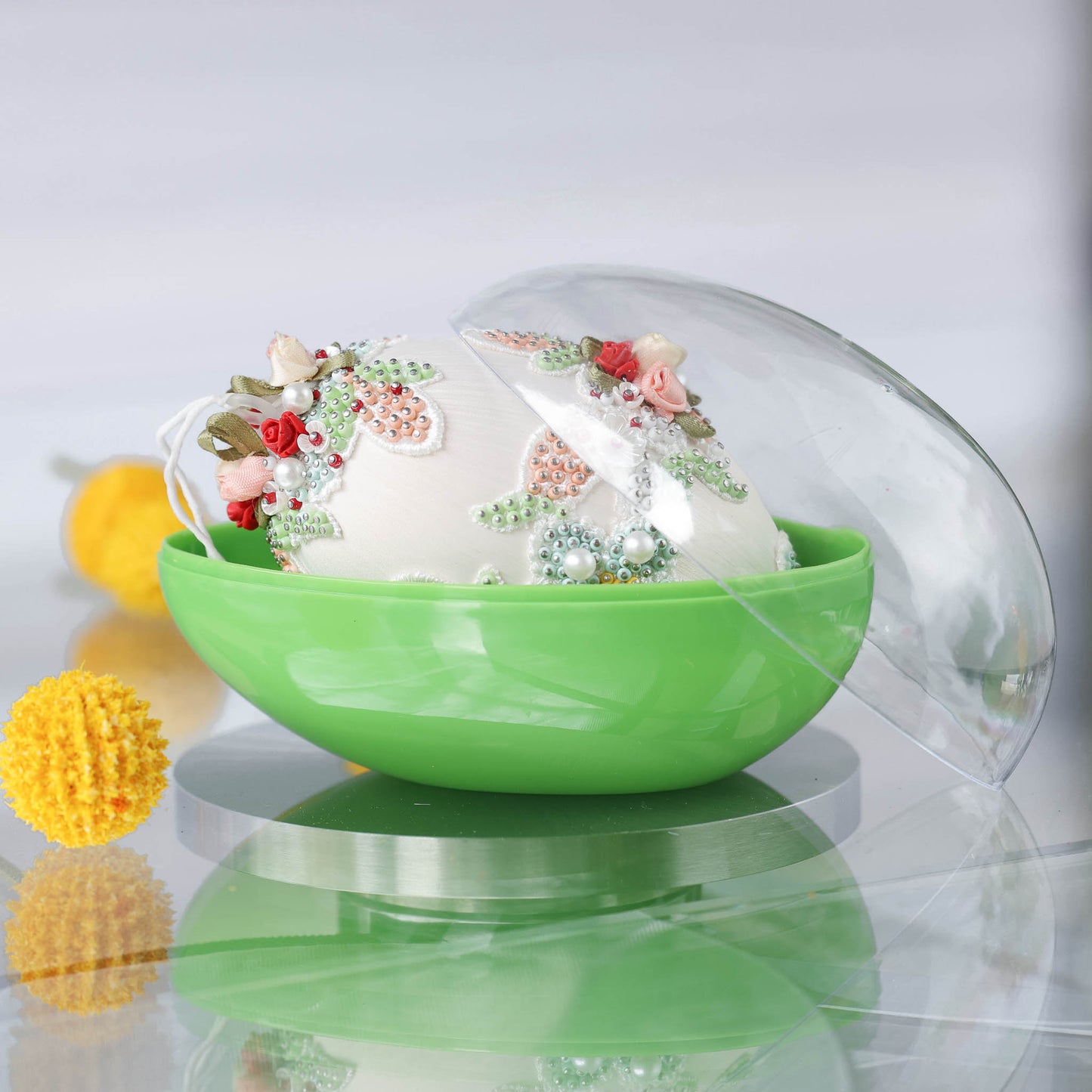 Decorative handmade large Easter egg ornament inside a green egg-shaped storage box with yellow flowers in the background by Whim5seasons. (Old Lace) 