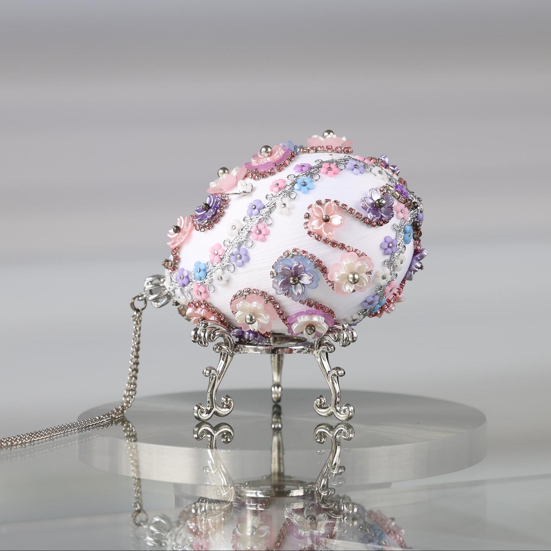 Handmade Easter Push Pin Ornament embellished with pink flowers, beads, and gold metallic trim on a silver stand against a light gray background by Whim5seasons.