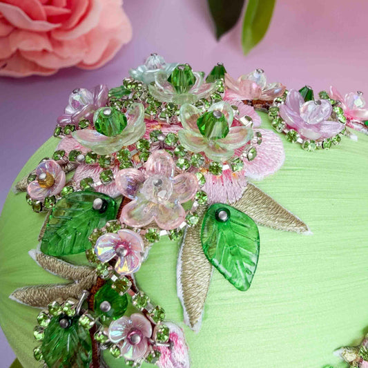 Detail of a handmade large Easter egg  push pin ornament showing small beads and flower charms pinned by hand to a foam core using dressmaker pins by Whim5seasons.