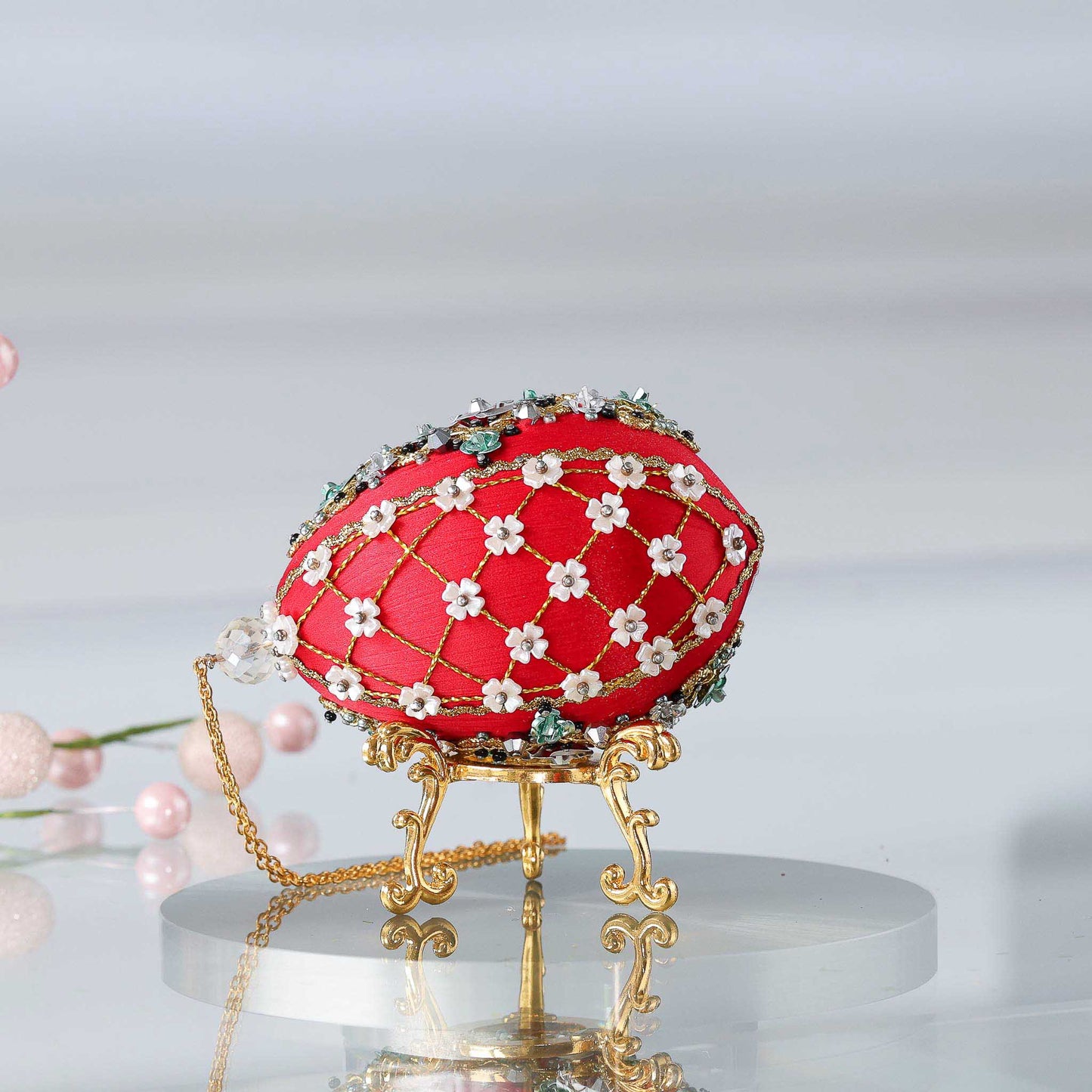 Handmade Easter Push Pin Ornament embellished with crystals, beads, and metallic trim on a gold stand against a light gray background by Whim5seasons. (Dark Red).