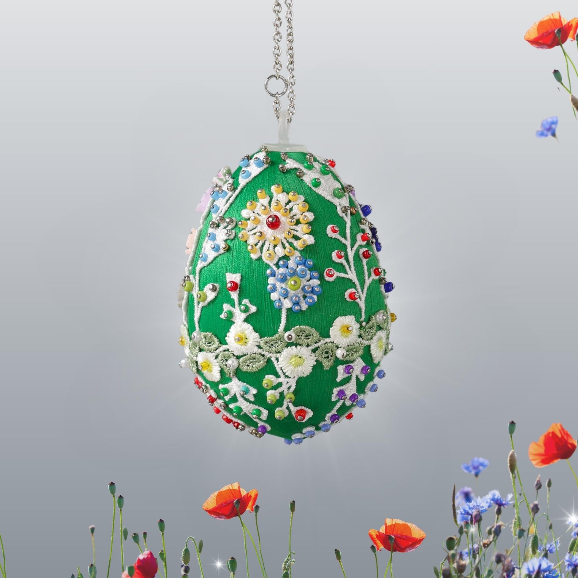 Decorative red satin Easter egg decoration with floral patterns hanging on a chain, placed in a woven basket with straw by Whim5seasons.
