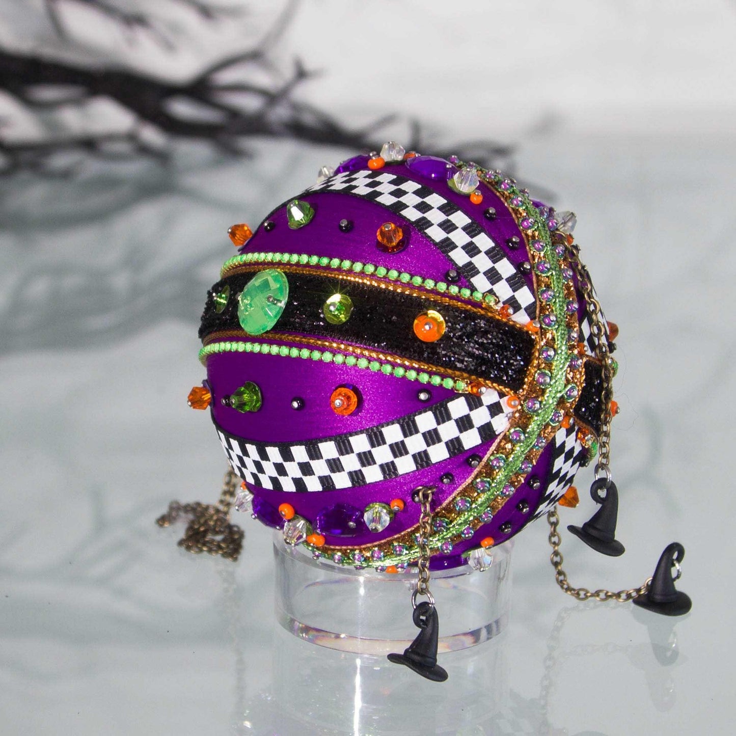 Bottom detail of a hand crafted satin Halloween or Christmas ornament adorned with mini witch hat charms, contrasting color trims, and metallic accents by Whim5seasons.