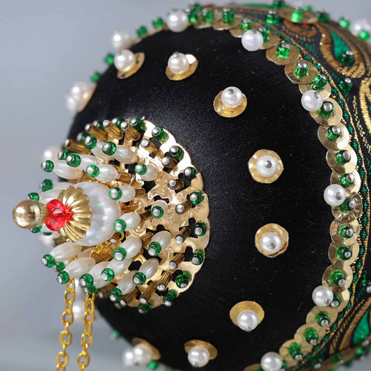 Close up of a handmade vintage 1970 Christmas beaded ornament featuring large metallic embellishment, pearls, and sequins, secured in place with dressmaker pins.