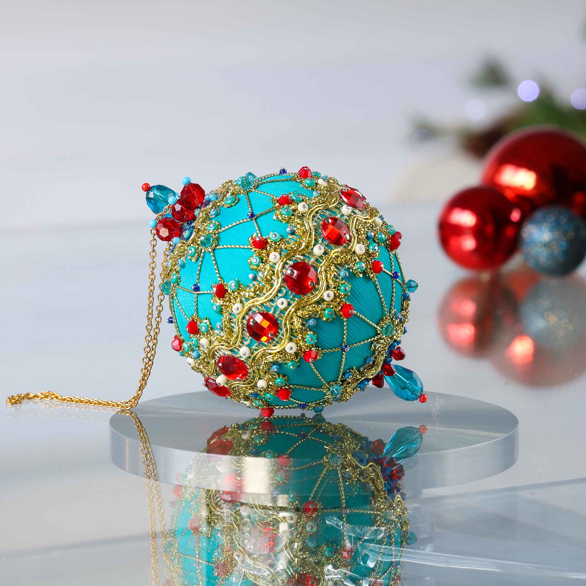 Close-up Detail of Scheherazade Handmade push pin ornament - teal-colored ball with red rhinestones, blue accents, sequins, seed beads, gold chain, and metallic cord. (Light Sea Green)
