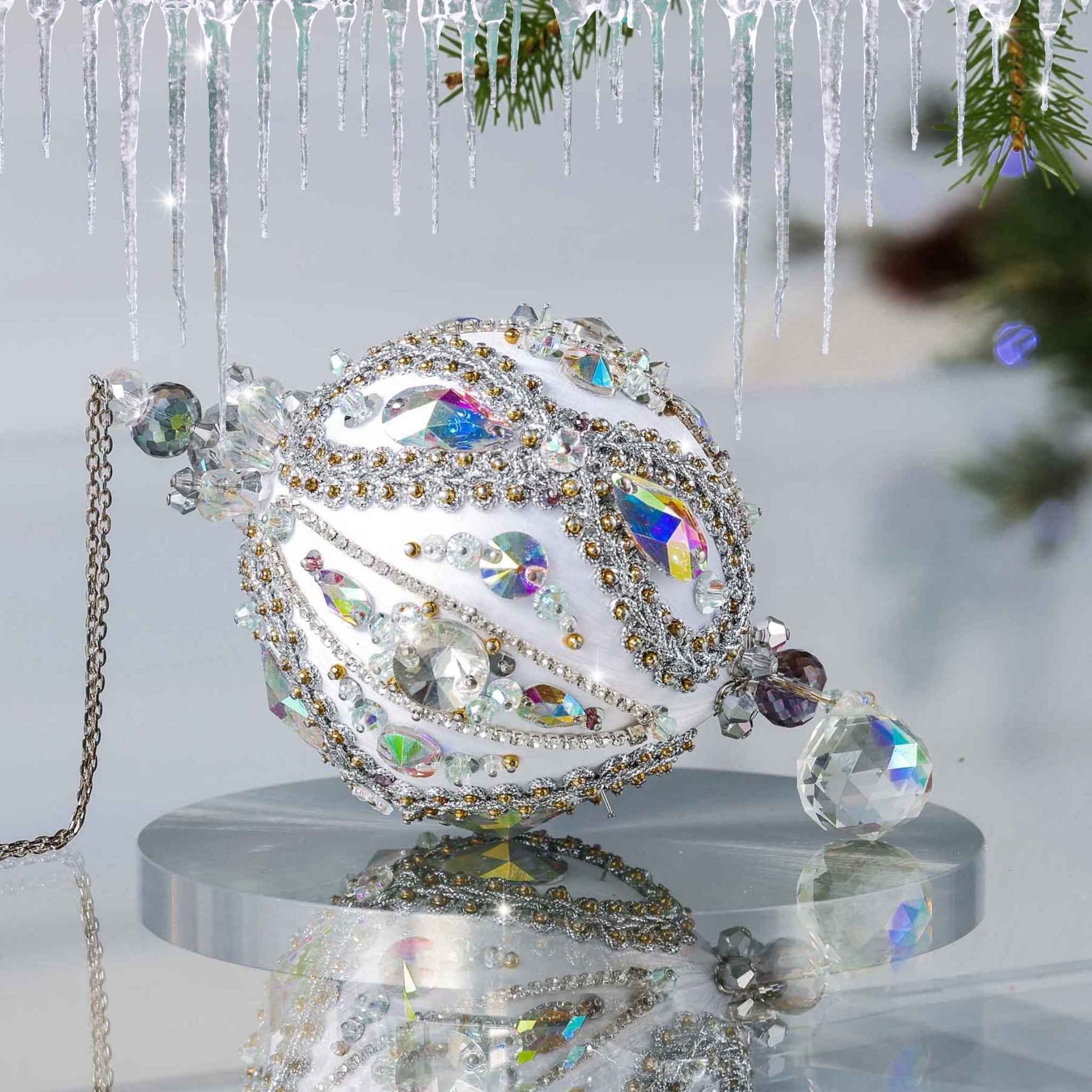 Handmade white satin push pin ornament featuring a large AB glass teardrop bead on the bottom with a Christmas branch in the background by Whim5seasons.