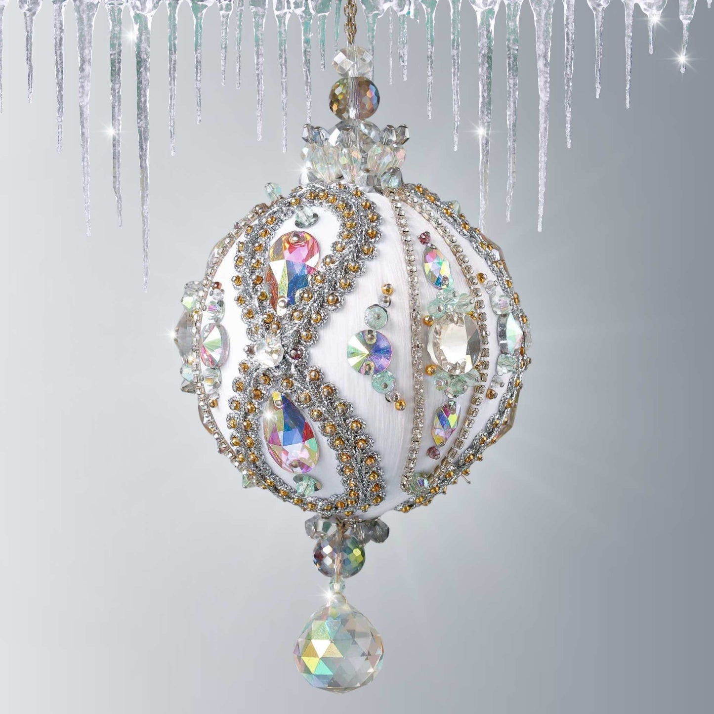Handmade white satin push pin ornament beaded with glass AB rhinestones, and hundreds of tiny seed beads, hanging on a chain in front of light gray background by Whim5seasons.