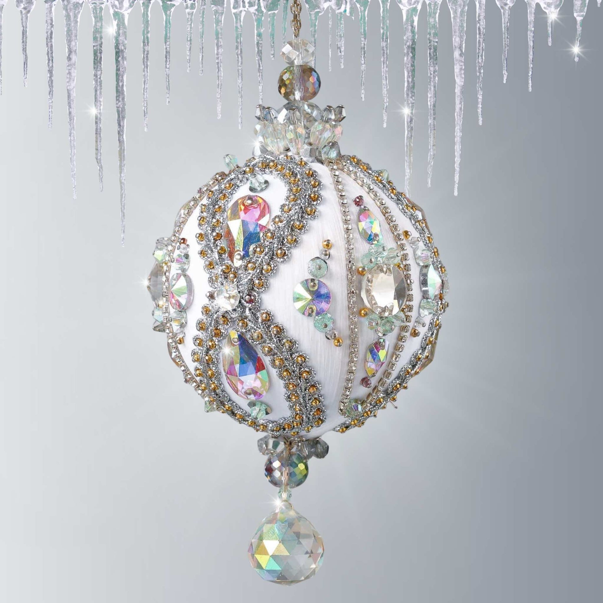 Handmade white satin push pin ornament beaded with glass AB rhinestones, and hundreds of tiny seed beads, hanging on a chain in front of light gray background by Whim5seasons.