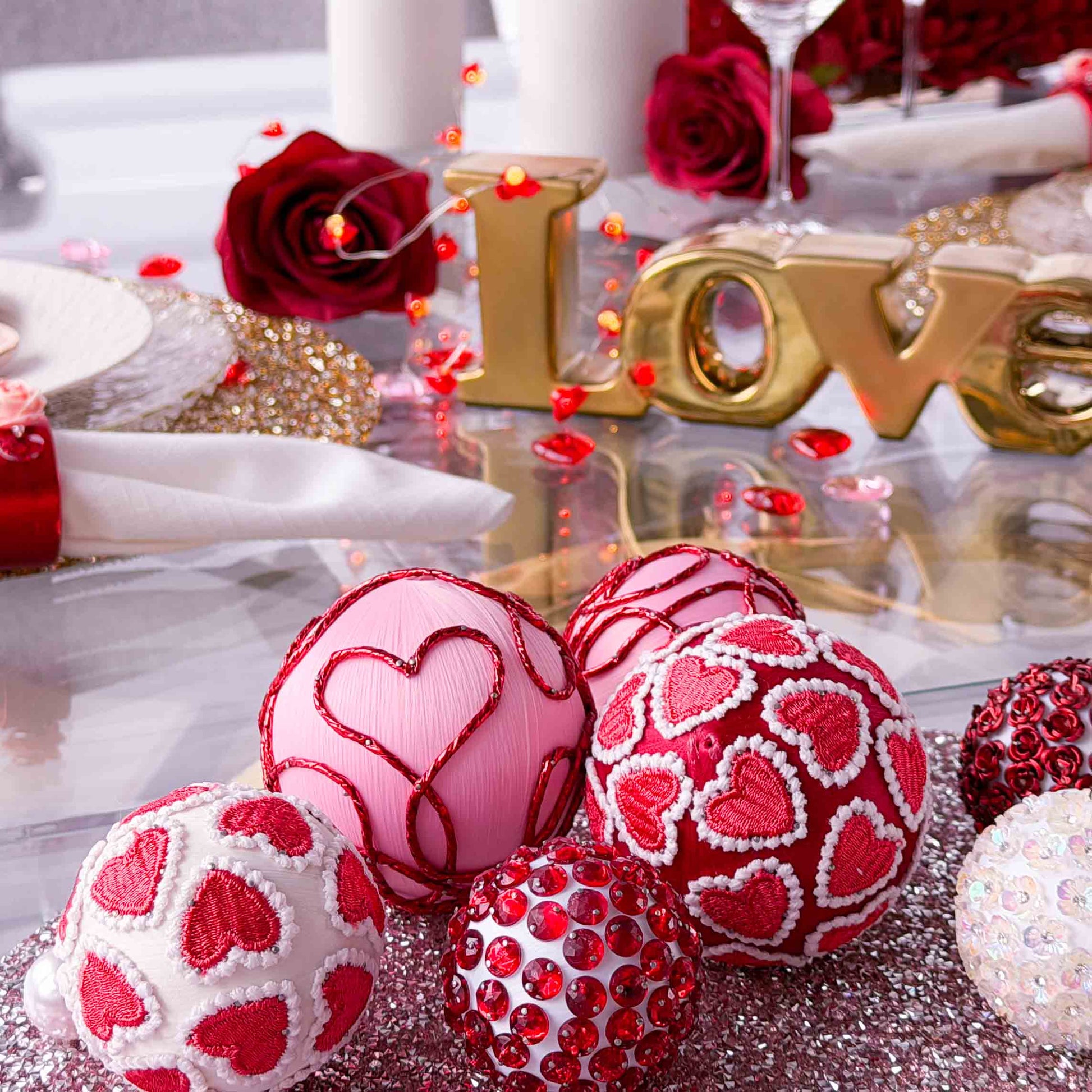 Decorative heart-themed satin beaded filler balls  on a table with 'LOVE' letters and red roses for Valentines Day table setting by Whim5seasons.