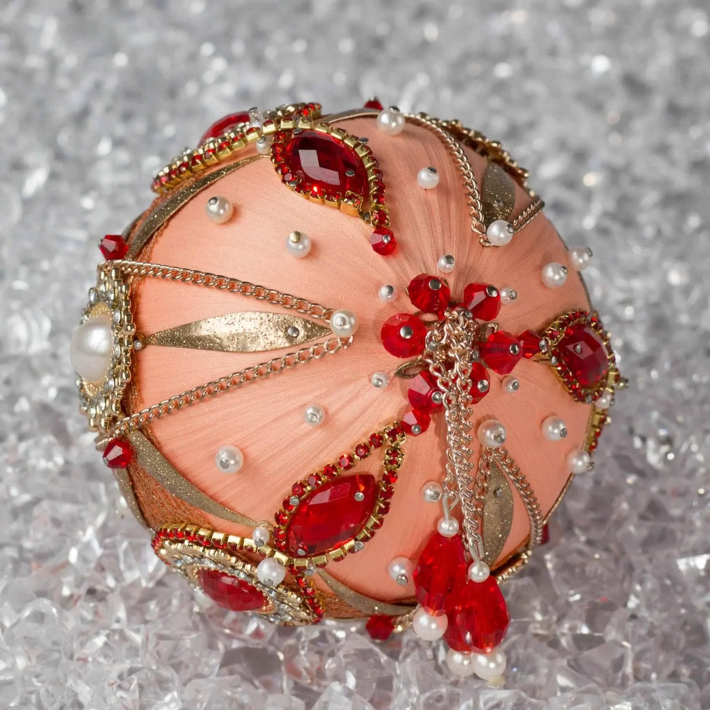 Close-up of Phoenix Christmas Beaded Handmade Satin Ornament, embellished with large gold cameos, rhinestones, gold alloy accents, and copper cobweb lace. (Coral)
