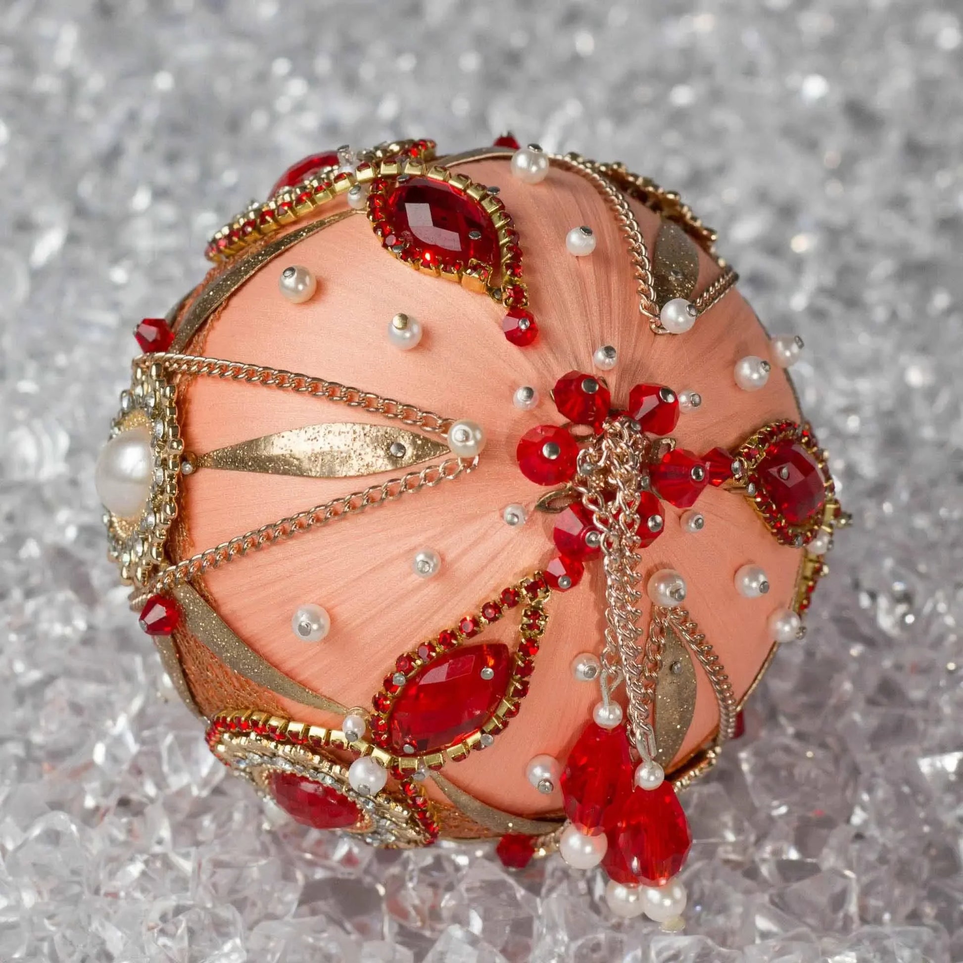 Close-up of Phoenix Christmas Beaded Handmade Satin Ornament, embellished with large gold cameos, rhinestones, gold alloy accents, and copper cobweb lace. (Coral)