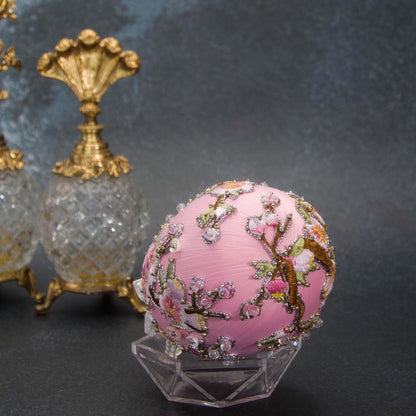 A bottom detail of Handmade Beaded Push Pin Easter Ornament  by Whim5seasons - white satin egg with pink plum bloom embroidery patches and silver cording. Faberge inspired.(Light Pink)