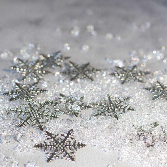 Christmas Craft Supplies: Close-up of six intricate silver snowflake filigree metal stampings - Whim5seasons.
