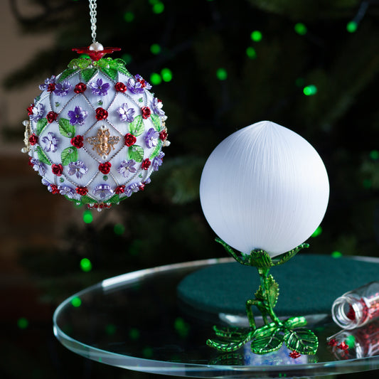 Decorative Christmas ornament satin kit with a white ball and green stand on a reflective surface. (White).