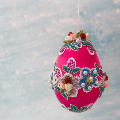 Vintage Doily in Hot Pink from Whim5seasons is a festive Easter Egg Ornament set against a background of a spring sky. (Deep Pink) 